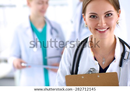 Attractive female doctor  with folder in front of medical group