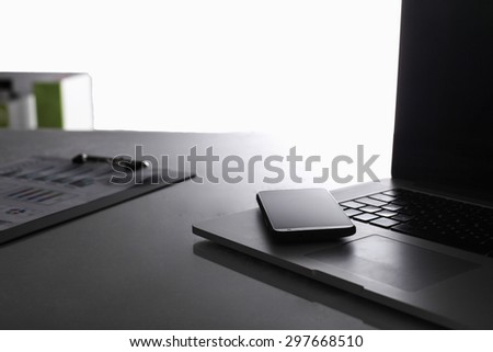 Modern home office with computer and laptop, folder, phone lying on the desk