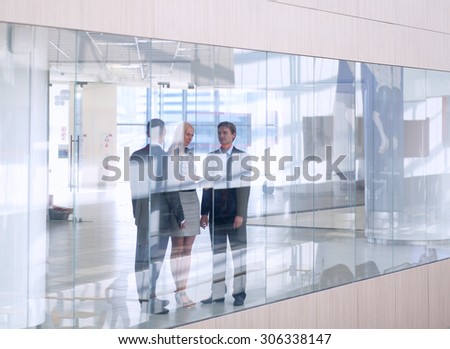 Business woman standing with her staff in background at modern office