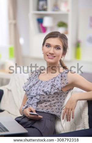 Young beautiful woman with a cup on sofa at home