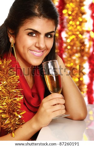 Beautiful young brunette woman drinking champagne at christmas party. Isolated on decorated background