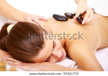 Girl on a stone therapy, hot stone massage. Isolated on white.