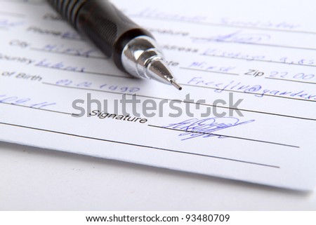 Sign the name on a paper with a pen