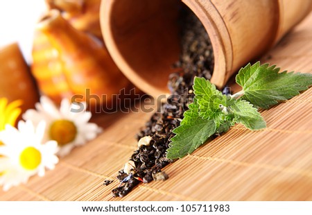 Closeup image of spilled tea and fresh mint leaf on bamboo cover