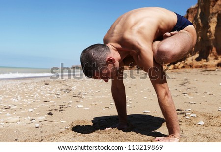 Yoga practice. Man doing pendulum yoga pose witt legs in lotus position