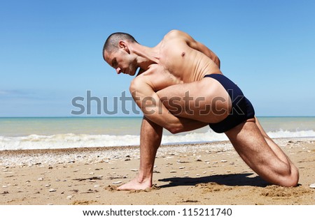 Yoga practice. Man in twisted side angle yoga pose with hands behind his back