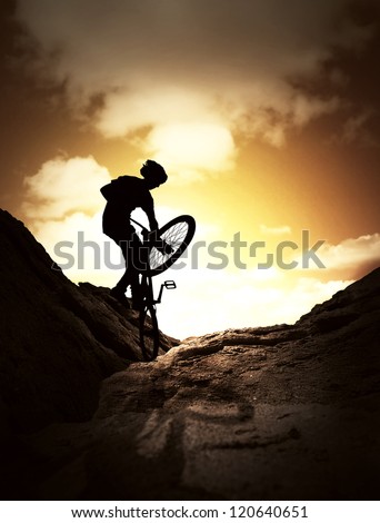 Silhouette  of  young man jumping on the mountain bike
