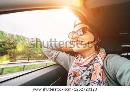 Woman enjoy with view from car window when traveling by auto selfie wide angle shot