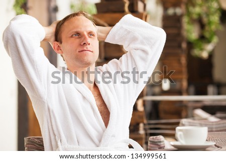 Handsome young man in bathrobe have relaxing morning time