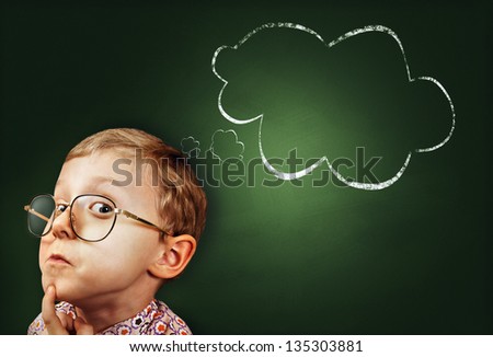 Thoughtful boy funny portrait with abstract idea clouds on chalkboard