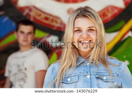 Open smiling pretty teenage girl on the graffity background