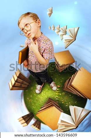 Clever little boy in glasses standing on abstract book planet