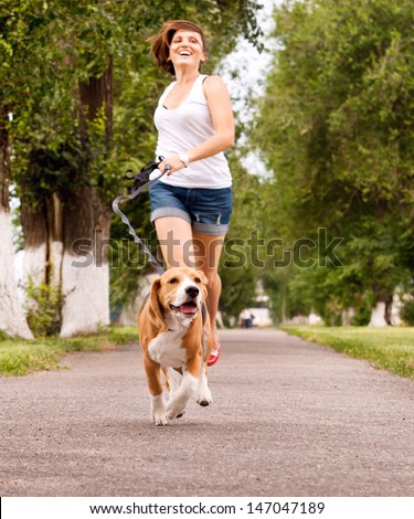 Happy Young Woman Jogging With Her Beagle Dog