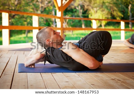 Yoga trainer show a difficult flexible yoga asana