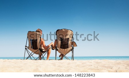 Love couple relaxing on the white sand beach.Clear blue sky and quiet sea