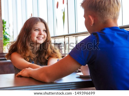 Teenage couple meeting in modern cafe