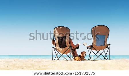 Love couple relaxing on the white sand beach with little beagle puppy dog