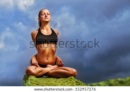 Perfect slim woman performs full close lotus yoga asana