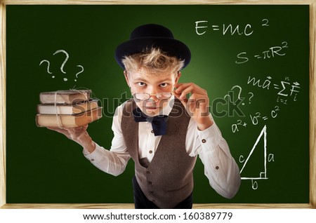 Questioning looking young man with old books near chalkboard