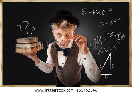 Questioning looking student with old books near chalkboard