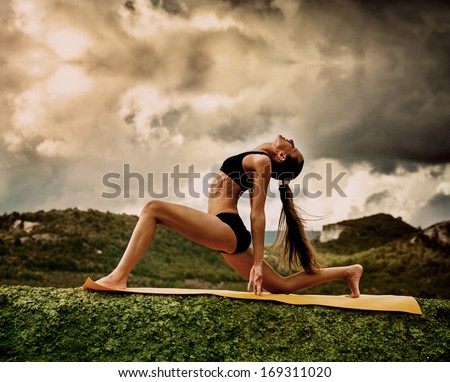 Slim Young Woman Makes Warrior Yoga Pose