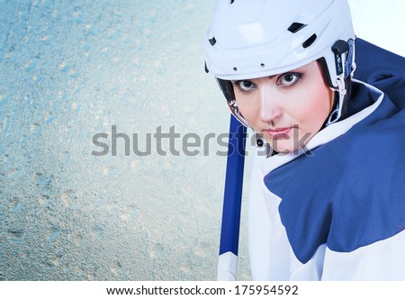 Beautiful ice hockey female player fashion portrait on the ice background