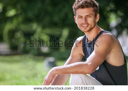 Attractive young man after sport training  in city park