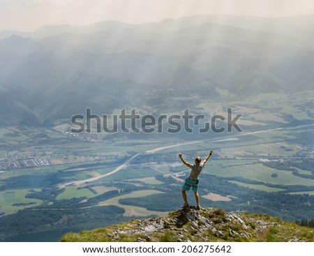 Extreme runner finally climbs the mountain top and see wide valley