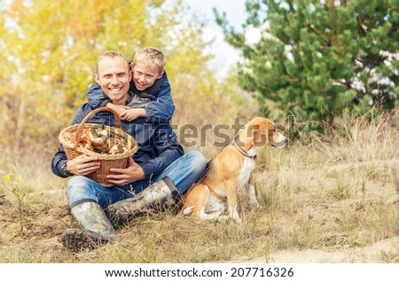 Father and little son happy with full basket of mushrooms Father and little son happy with full basket of mushrooms