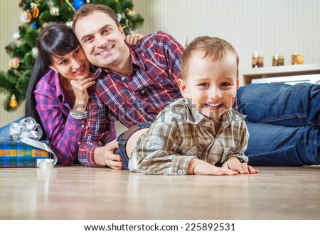Beautiful young family under the christmas tree at home