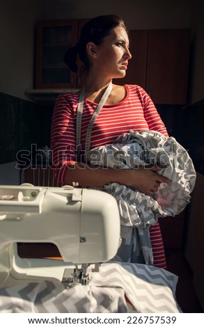 Tailor woman looks in window with work in hands