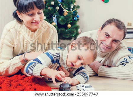 Parents playing with his son with Santa's gifts