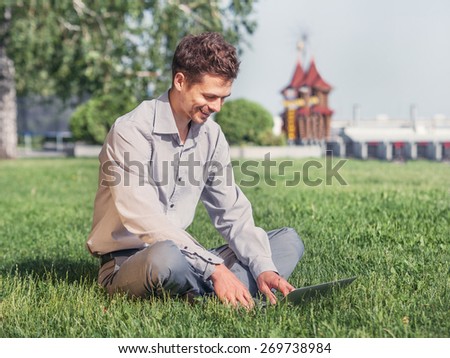 Young man work with laptop in the city park