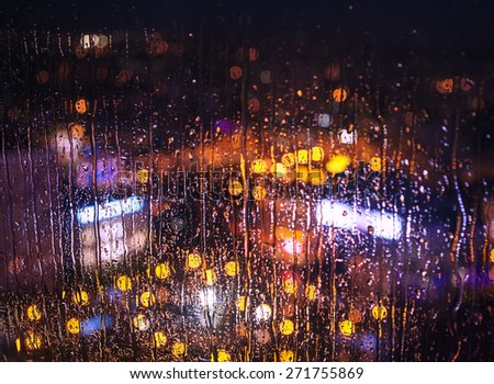 Night city lights behind rainy window