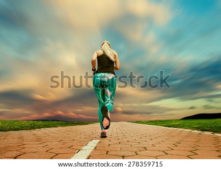 Young blonde girl evening jogging with great cloudscape