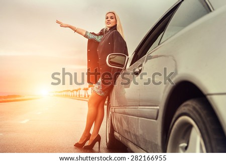 Lady in high heel shoes with broken car on the highway