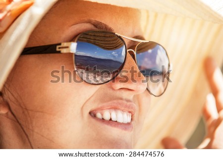Close up woman portrait in sun glass mirrored sea