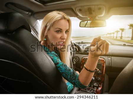 Attractive blonde female emotional talks to rear seat passenger