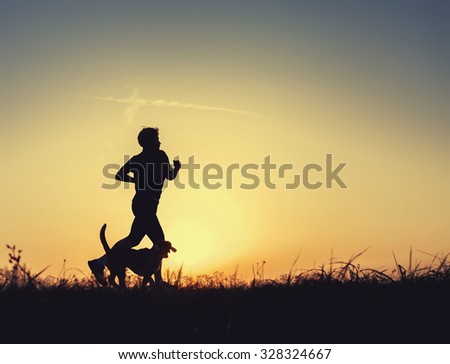 Runner and dog silhouettes in sunset time