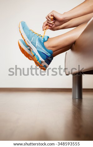 Runner lace her run shoes sitting in bed