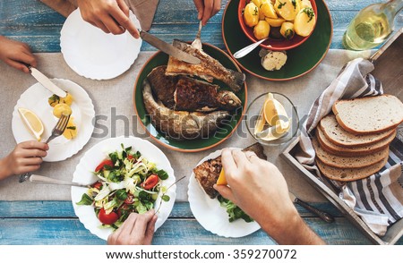 Family dinner with fried fish, potato and salad
