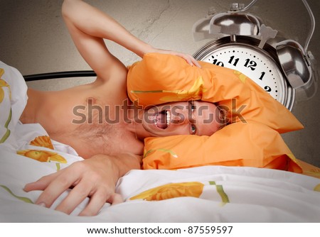 Terribly loud alarm clock at early morning for the sleeping man