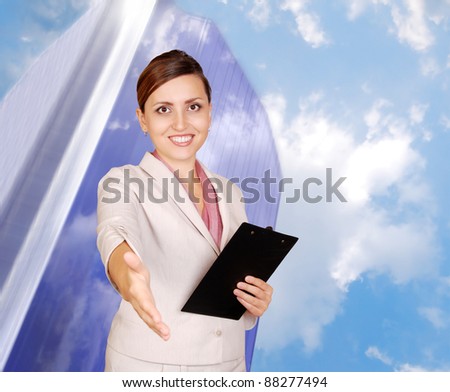Smiling business woman with hand outstretched for a handshake on the business center and sky background