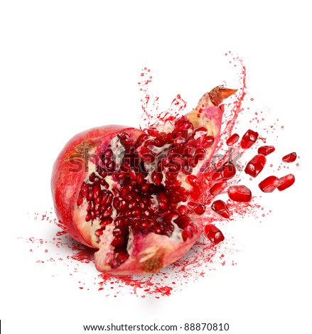 Falling down ripe pomegranate with cracks and splashes of juice and seeds on white background