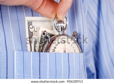 Close up view on stopwatch and banknotes into the pocket of shirt