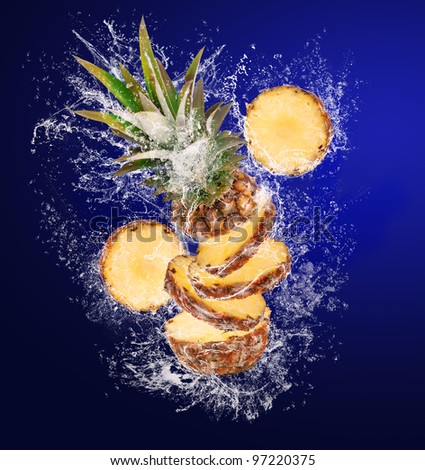 Sliced Pineapple falling in abstract water drops on blue background