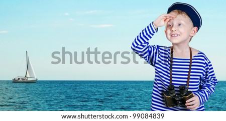 Little ship boy with binoculars looks into the distance from the arm at the sea view