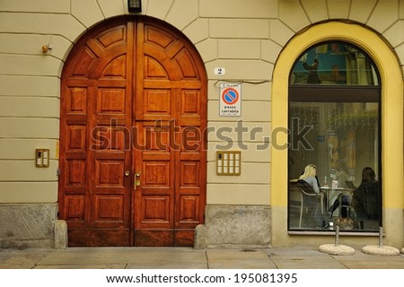 main entrance door and window with sitting people, Turin, Italy