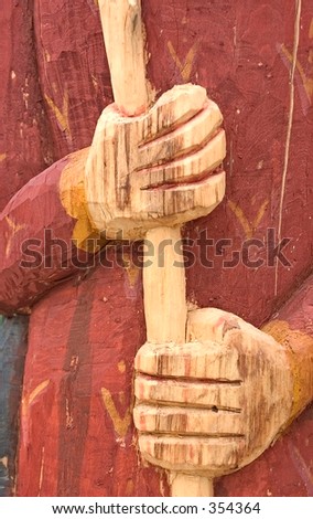 Hands on a sculpture carved from a tree trunk in a park in Santa Fe, NM