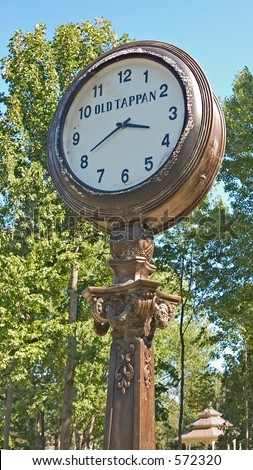 Antique brass pedestal clock in a park in Old Tappan, NJ.
